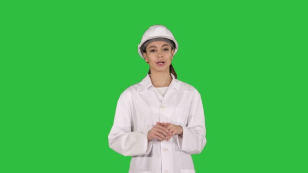 Μια νεαρή όμορφη γυναίκα επιστήμονας μηχανικός σε λευκό δίνει διάλεξη σχετικά με μια πράσινη οθόνη, Chroma Key. — Αρχείο Βίντεο