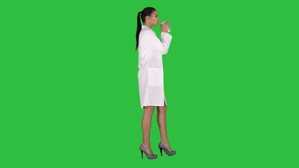 Női orvos kávét iszik, és séta a Green Screen, Chroma Key. — Stock videók