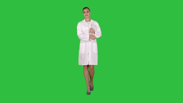 Γυναίκα γιατρός περπάτημα με tablet hands σε μια πράσινη οθόνη, Chroma Key. — Αρχείο Βίντεο