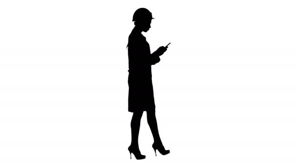 Инженер-силуэт, использующий смс-ки на мобильном телефоне во время ходьбы. — стоковое видео