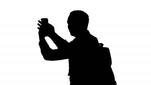 Silhouette Handsome young man carrying backpack and taking a picture of himself. — Stock Video