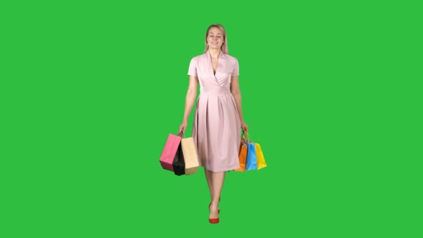 Winkelen vrouw met winkelen lopen naar de camera op een groen scherm, Chromakey. — Stockvideo