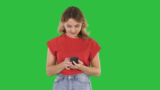 Joven hermosa mujer en camiseta usando su teléfono inteligente en una pantalla verde, Chroma Key . — Vídeos de Stock