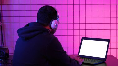 Kulaklıklı bir adam evde video oyunu oynuyor. Beyaz Görünüm.