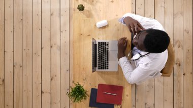 Uyku ve bir telefon olan Afro Amerikalı doktor adam.