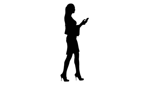 Silhouet jonge vrouw lopen met boodschappentassen praten op mobiele telefoon. — Stockfoto