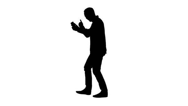 Silhouette Leisure, technology, communication and people concept - young man using and calling on smartphone while walking. — Stock Photo, Image