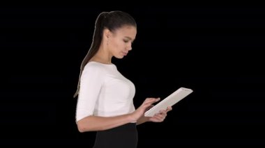 Yürürken dijital tablet kullanan çekici iş kadını, Alpha Channel