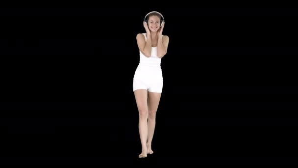 Šťastná dívka v konzumní volnočasové poslech hudby a chůzi, alfa kanál — Stock video