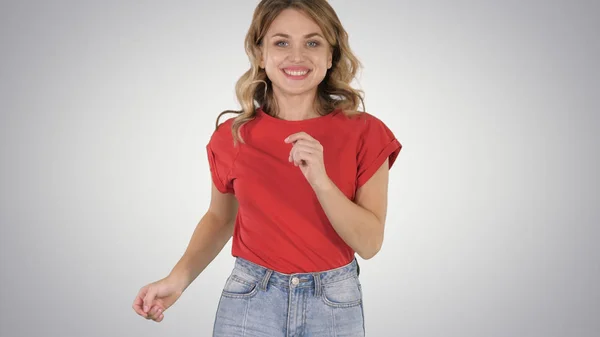 Menina correndo vestindo camiseta vermelha e jeans Sorrindo no fundo gradiente . — Fotografia de Stock