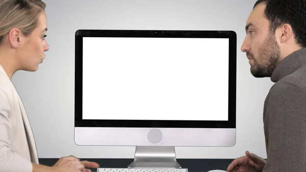 Colegas de negócios um homem e uma mulher tendo uma conversa sobre o que está na tela do computador no fundo gradiente . — Fotografia de Stock