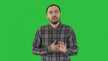 Çekici bir genç adam bir yeşil ekranda Chroma Key çalıştırdıktan sonra yorgun.
