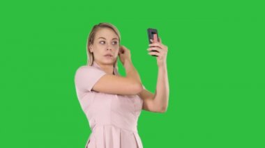 Sarışın kadın bir yeşil ekran, Chroma Key Smartphone'da önünde ayrılmadın. 4 k çözünürlüklü profesyonel vurulmuş. 005. Örneğin kullanabilmeniz için reklam videosu, iş, tanıtım, yayın