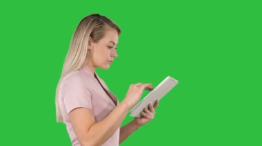 Dijital tablet Chroma anahtar yeşil ekranda bir şey için arama tutan kız.