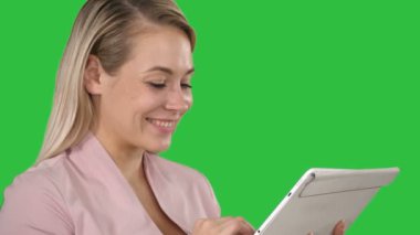 Bir tablet bilgisayar üstünde a yeşil perde, Chroma Key kullanarak gülümseyen iş kadını.