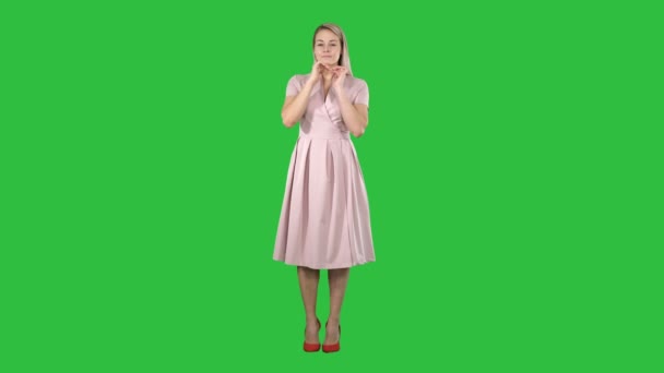 Vacker anbud flicka i rosa klänning spegeln och tittar på en grön skärm, Chroma Key. — Stockvideo