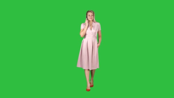 Portrét chodící šťastné mladé ženy mluvit na mobilním telefonu a usmívá se na zelené obrazovce, Chroma Key. — Stock video