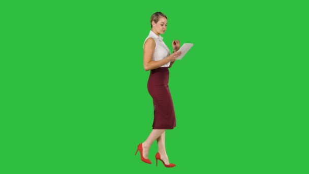 Mujer de negocios utilizando ficha electrónica caminando en una pantalla verde, Clave de croma . — Vídeos de Stock