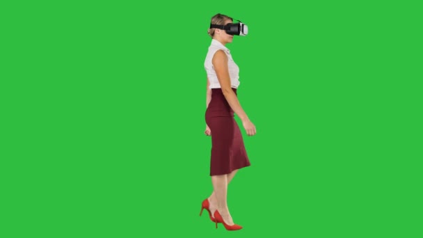 Νεαρή γυναίκα, φορώντας συσκευή εικονικής πραγματικότητας και το περπάτημα σε μια πράσινη οθόνη, Chroma Key. — Αρχείο Βίντεο