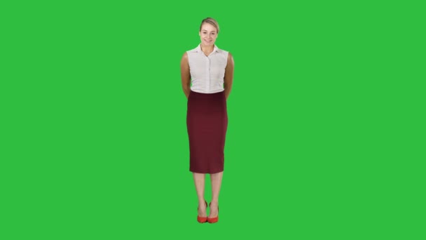 Attraktive schüchterne Geschäftsfrau, die auf einem grünen Bildschirm steht und in die Kamera schaut, Chroma-Schlüssel. — Stockvideo