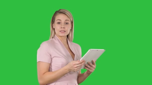 Женщина использует цифровой планшет и разговаривает с камерой на зеленом экране Chroma Key . — стоковое видео