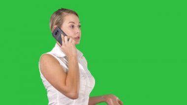 Büyüleyici bir iş kadını Chroma anahtar yeşil ekranda dururken hücre telefon ile arama.