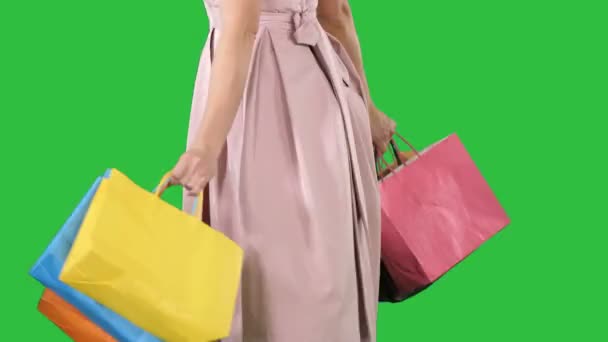 Femme tenant des sacs à provisions dans ses mains et tournant sur un écran vert, Chroma Key . — Video