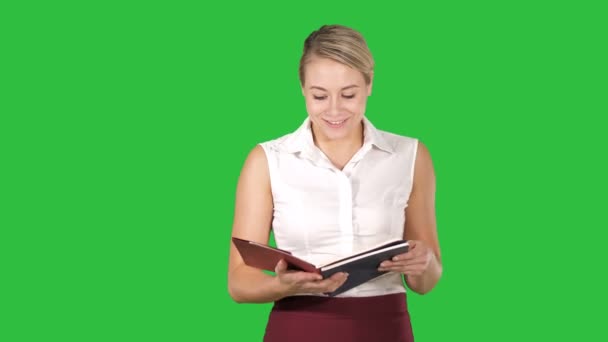 Kvinna håll och öppna bok eller anteckningsboken läsa något högt på en grön skärm, Chroma Key. — Stockvideo