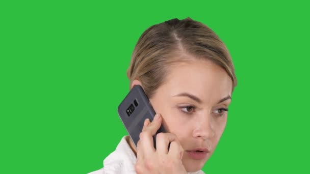 Женщина с светлыми волосами разговаривает по мобильному телефону на зеленом экране, хрома ключ . — стоковое видео