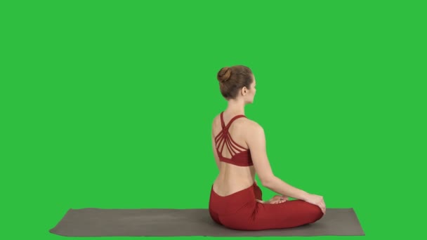 练习瑜伽莲花姿势的运动女子, 转向相机, 微笑在绿色屏幕上, 色度键. — 图库视频影像