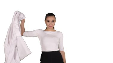Çekici kadın doktor beyaz arka planda beyaz cüppesini çıkarıp yürüyor..