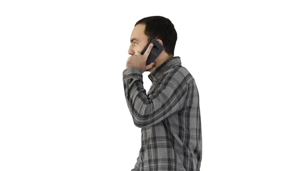 Jovem legal com barba andando e conversando com telefone celular no fundo branco. — Fotografia de Stock