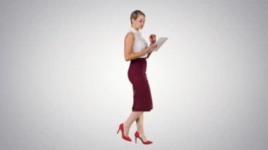 Degrade arka plan üzerinde yürüme elektronik sekmesini kullanarak iş kadını.