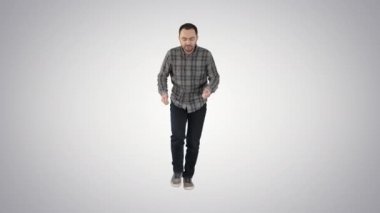 Yürüyüş ve degrade arka plan üzerinde dans rahat bir kıyafet içinde genç adam.