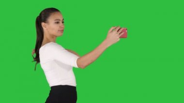 Orta yan görünüm vurdu. Bir selfie alarak ve yeşil ekranda Chroma Key yürüyüş güzel kız. 4 k çözünürlüklü profesyonel vurulmuş. 013. sen-ebilmek kullanma o bir örneğin ticari video, işinizde