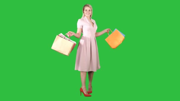 Щасливі молоду жінку, роблячи свою чергу, з сумками в руках дивлячись на камеру на зелений екран, Chroma Key. — стокове відео