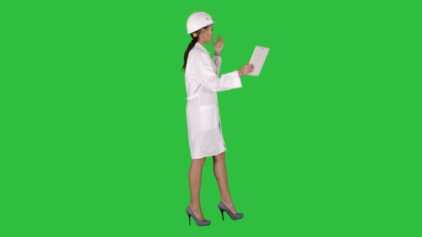 Vrouw ingenieur met tablet maken video bellen op een groen scherm, Chromakey. — Stockvideo