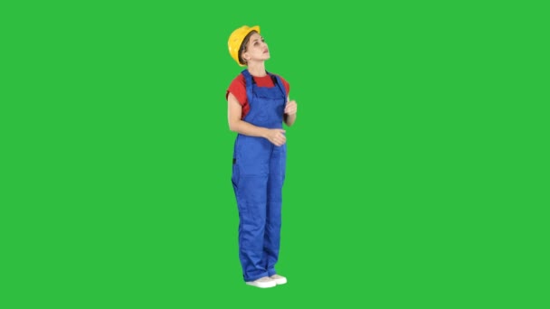 Engineer woman in yellow helmet looking up amazed at a building or statistics or graph on a Green Screen, Chroma Key. — Stock Video