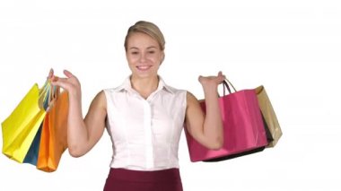 Beyaz arka planda alışveriş yaparken alışveriş torbalarını tutan genç bir kadın..