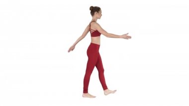 Yürüyüş ve beyaz arka plan üzerinde ellerini sallayarak sarışın yoga eğitmeni.