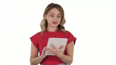 Kırmızılı sarışın kadın tablet tutuyor ve beyaz arka planda kameraya okuyor..