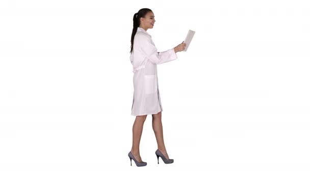 Молодая женщина врач держит планшет в руках и делает видеозвонок на белом фоне. — стоковое видео