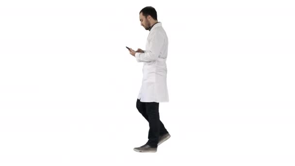 Médico masculino andando e usando telefone celular no fundo branco . — Vídeo de Stock