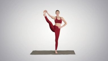 Kadın Yoga modeli yapma ayakta Split gülümseyen degrade arka plan üzerinde.