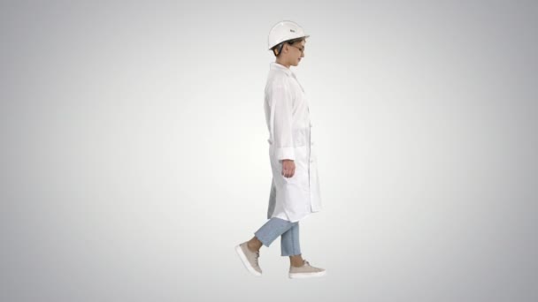 Walking woman engineer with hands in pockets on gradient background. — Stock Video