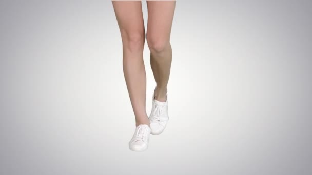 Patas femeninas en zapatillas de gradiente caminando sobre fondo de gradiente. — Vídeo de stock