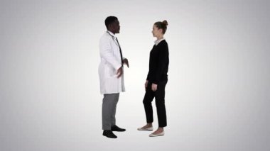 Degrade arka plan üzerinde genç kadına ilaç erkek doktor sunar.