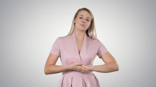 Femme en rose parlant à la caméra sur fond de dégradé. — Video