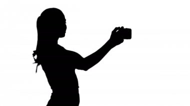 Siluet Güzel kız selfie çekiyor ve yürüyor.