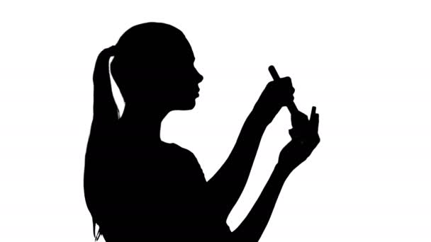 Силуэт Молодая красивая женщина наносит порошок на щеку кистью . — стоковое видео
